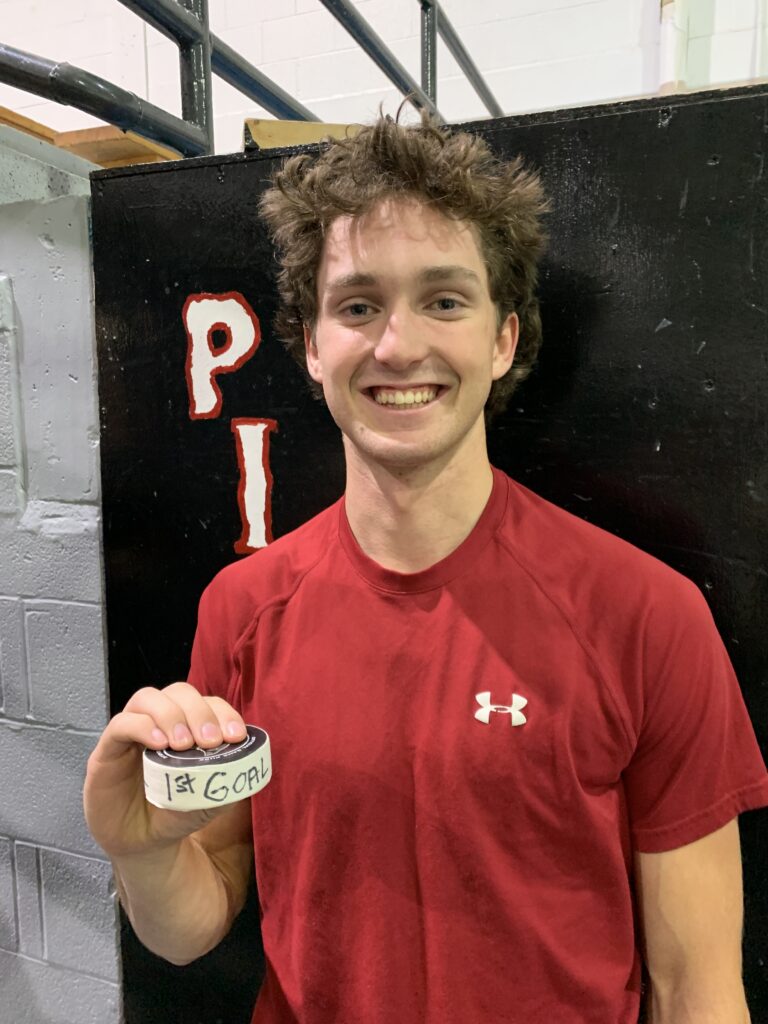 Tyler Hall poses with the souvenir puck from his first junior goal.