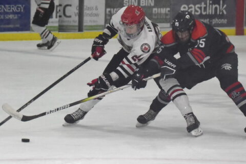 Cole Lavender shields the puck from the clutches of Port Hope Panther Cole Harvey during Picton’s 7-2 win Thursday night. (Jason Parks/Gazette Staff)