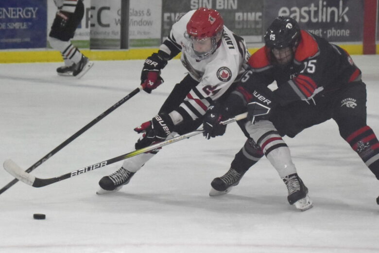 Cole Lavender shields the puck from the clutches of Port Hope Panther Cole Harvey during Picton’s 7-2 win Thursday night. (Jason Parks/Gazette Staff)